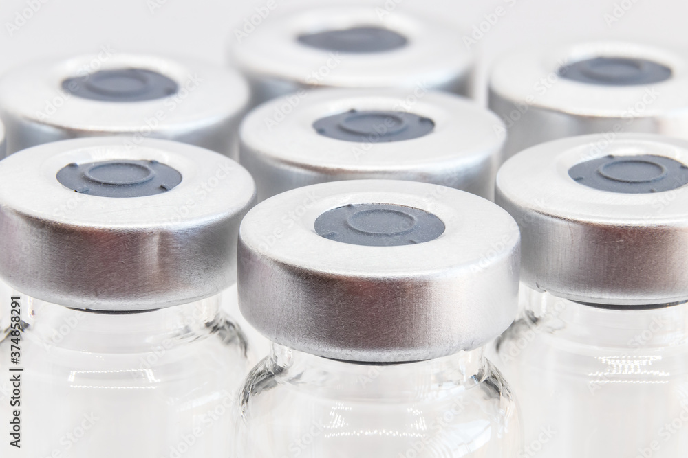 Macro photography of glass vials for liquid samples and vaccines. focus on first vial. Shallow depth of field.