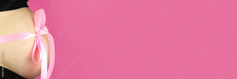 Pink bow on pregnant belly, horizontal banner, copy space for text