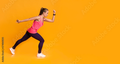 Motivated Young Woman In Sportswear Running Over Yellow Background