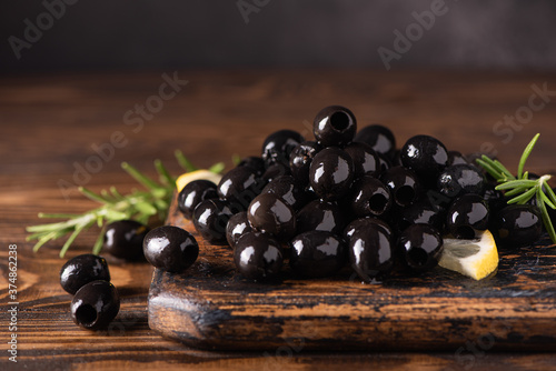 Foto pitted black olives on wooden board