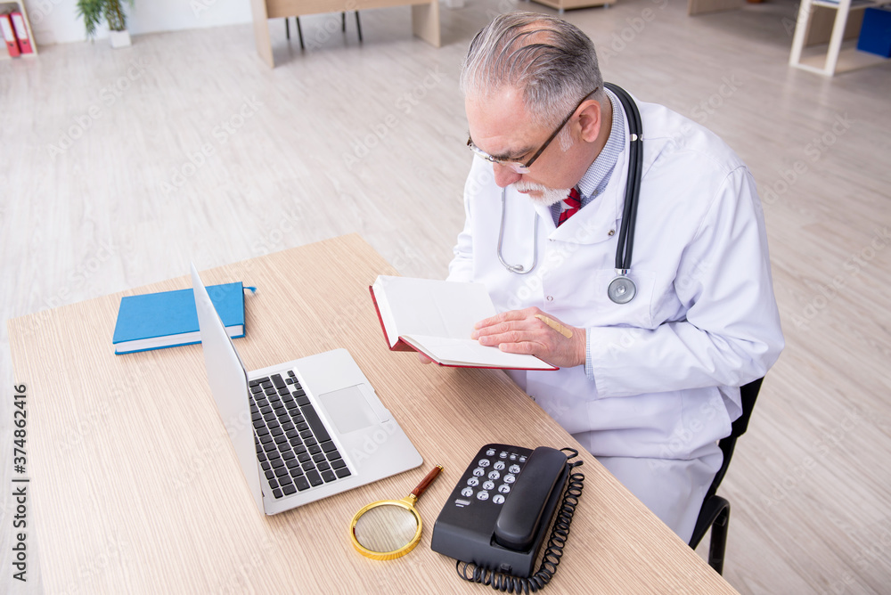 Old male doctor working in the clinic Old male doctor working in the clinic