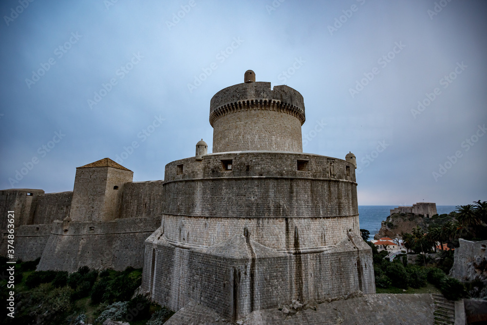 Fortress from outside, overcast blue-sky moody day. Scenery winter view of Mediterranean old city of Dubrovnik, famous European travel and historic destination, Croatia