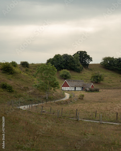 An old half-timbered house at the end of a winding gravel road in the rural area of Österlen, Sweden photo