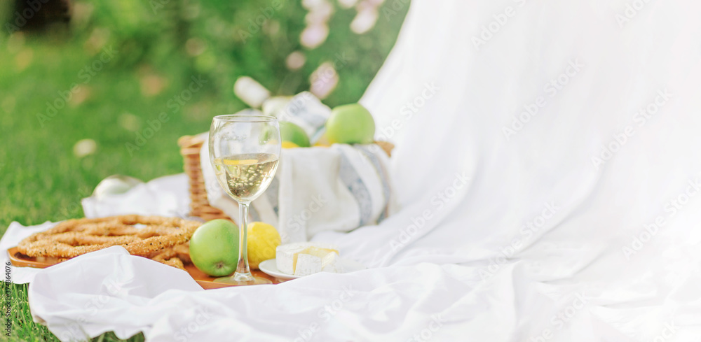 Copy space breakfast at sunrise, on the grass white sheet with a tray with cheese and vine, dry bread, apple, lemon. romantic mood, slow lifestyle aestetic concept, top view Copy space breakfast at sunrise, on the grass white sheet with a tray with cheese and vine, dry bread, apple, lemon. romantic mood, slow lifestyle aestetic concept, top view