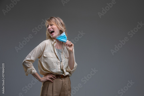Screaming Blond woman take off her surgical mask