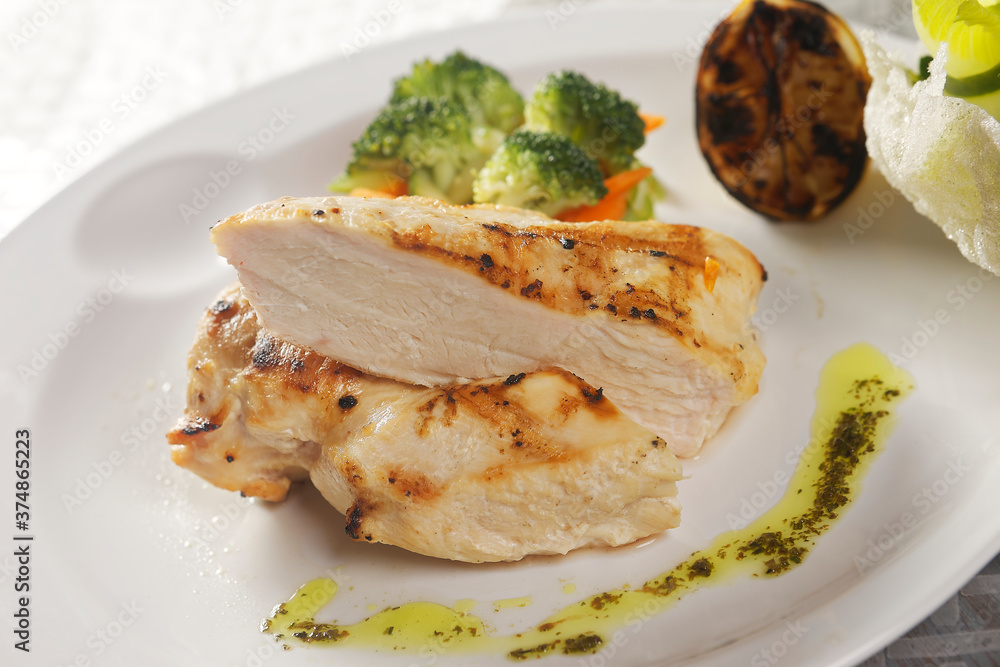 Roasted chicken breast served with a lettuce salad garnished with broccoli, carrot, pumpkin, and lemon juice. Roasted chicken breast served with a lettuce salad garnished with broccoli, carrot, pumpkin, and lemon juice.