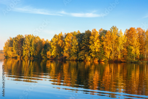 Obraz na płótnie Sunny autumn morning on lake. Landscape. View from the bech to forest. Golden forest. Reflection of the autumn forest in the water. w salonie