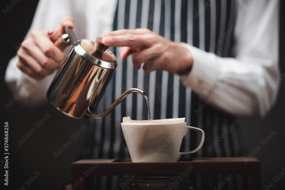 Hand drip coffee filter, barista pouring hot water on roasted coffee ground with filter