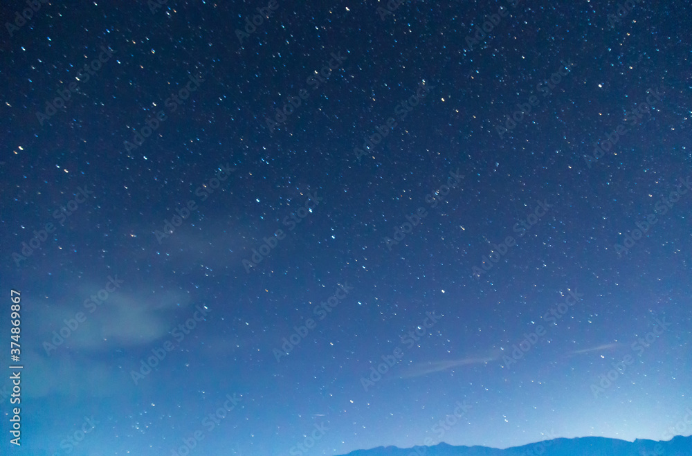 Starry sky and clouds. Over the high mountains.