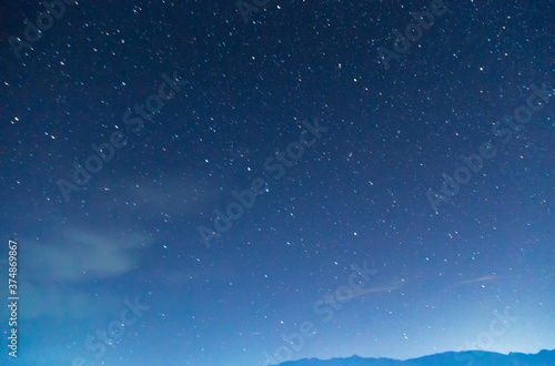 Starry sky and clouds. Over the high mountains.