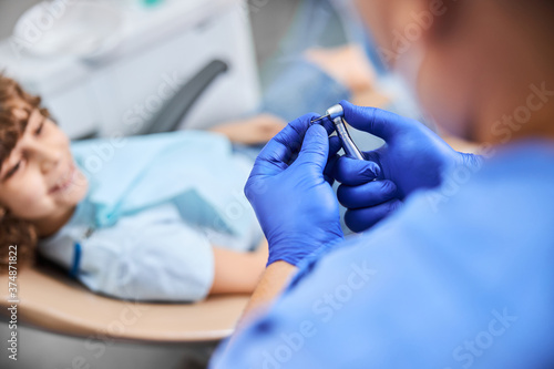 Dentist starting a dental drill for treating cavities