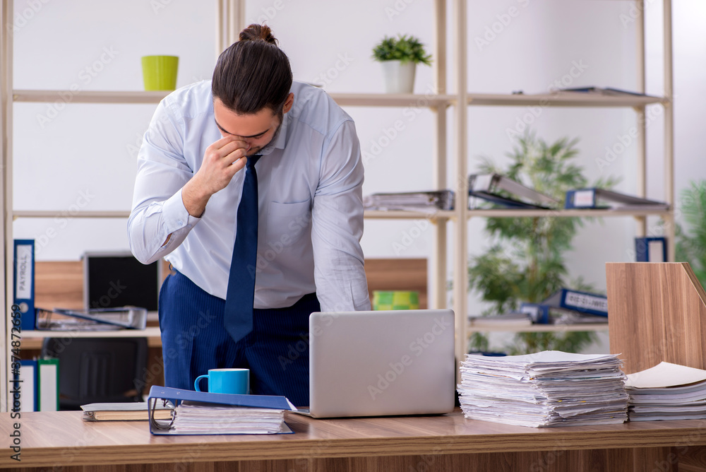Young male employee unhappy with excessive work Young male employee unhappy with excessive work