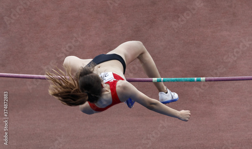 Athlete jumping over the bar in the pole vault sport