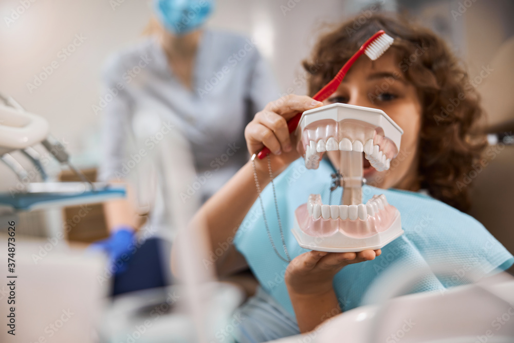 Curious child exploring jaw props at dental clinic