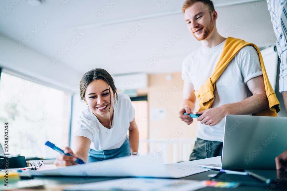 Obraz premium Positive lady drawing sketch of project with colleague