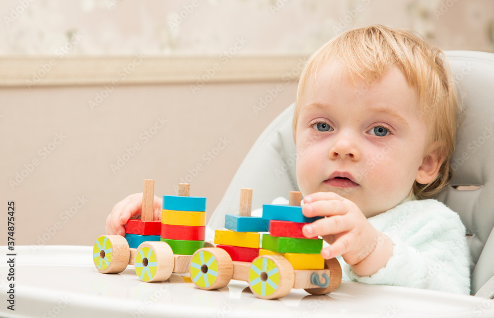 An inquisitive kid plays with educational toys while sitting at his children's table. Close up. Copy space An inquisitive kid plays with educational toys while sitting at his children's table. Close up. Copy space