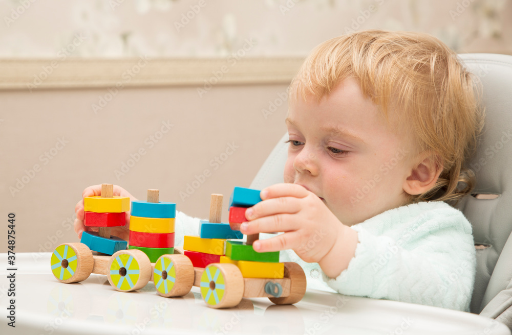 An inquisitive kid plays with educational toys while sitting at his children's table. Close up. Copy space. An inquisitive kid plays with educational toys while sitting at his children's table. Close up. Copy space.