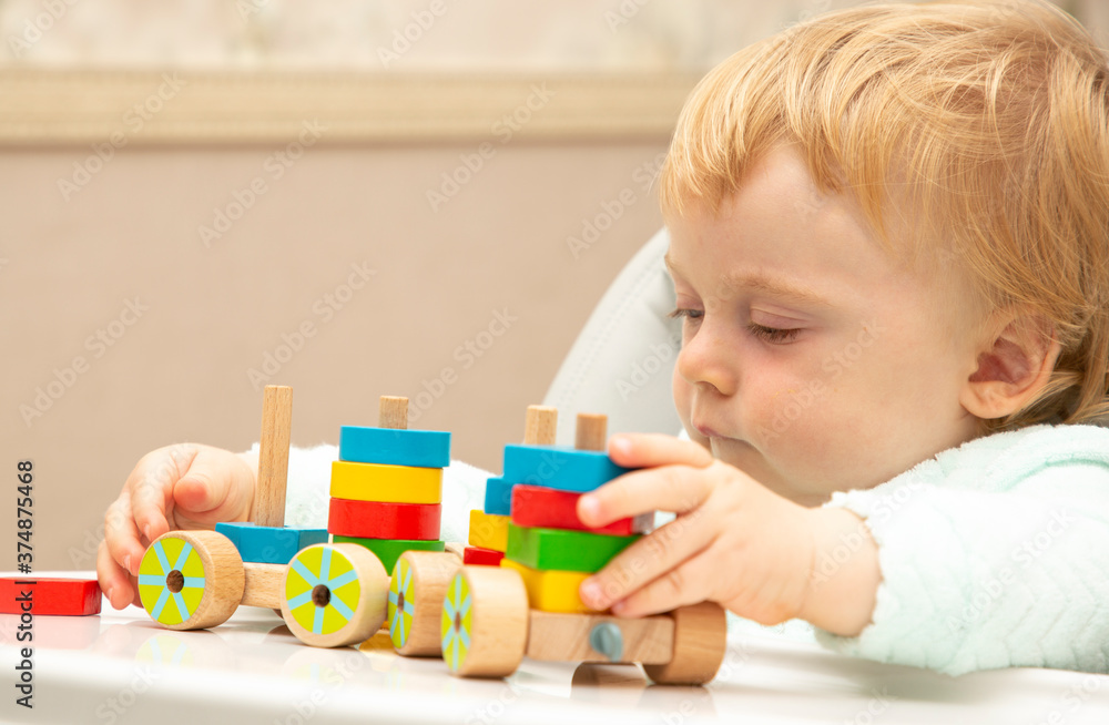 An inquisitive kid plays with educational toys while sitting at his children's table. Close up. Copy space An inquisitive kid plays with educational toys while sitting at his children's table. Close up. Copy space