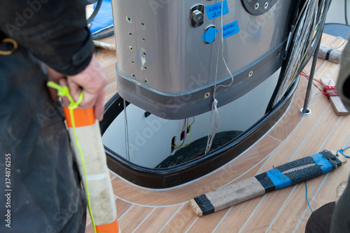 Placing a mast on a super sailing yacht at the harbor. Ship building industry. Shipyard. Building superyachts. Rigging.  photo