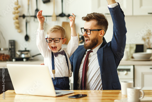 Cheerful businessman with kid celebrating success.