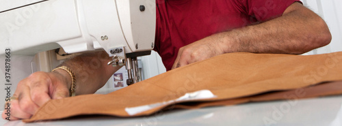 Tailor working on leather. Sewing machine. Ship building industry. Shipyard. Building superyachts.