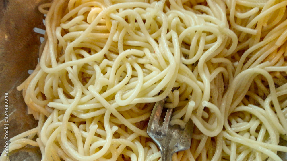 Large bowl with freshly cooked pasta and metal fork closeup Large bowl with freshly cooked pasta and metal fork closeup
