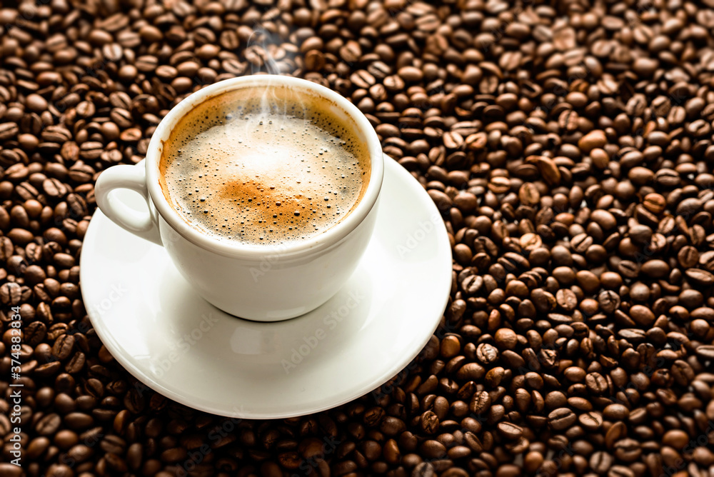 Cup with coffee on the background of coffee beans Cup with coffee on the background of coffee beans