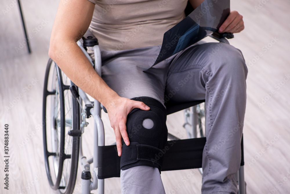 Young leg injured man in wheel-chair looking x-ray Young leg injured man in wheel-chair looking x-ray