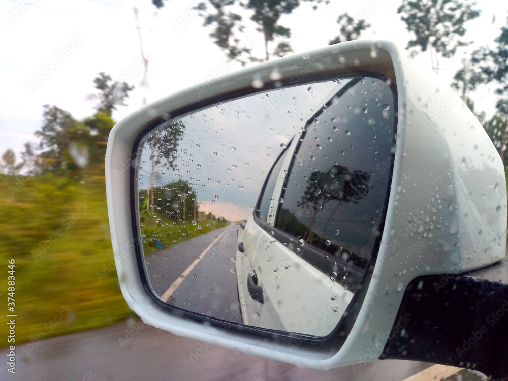 The view in the car side mirror When the weather is closed, the rain is about to fall in the rural roads of Thailand. The view in the car side mirror When the weather is closed, the rain is about to fall in the rural roads of Thailand.