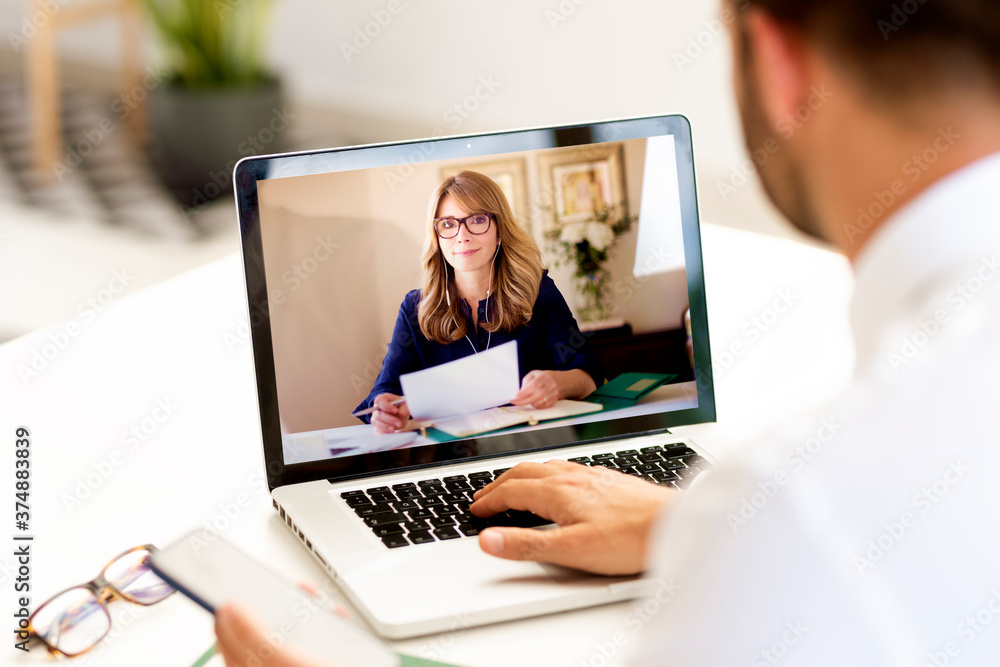 Rear view shot of businessman having discussion and online meeting in video call Rear view shot of businessman having discussion and online meeting in video call