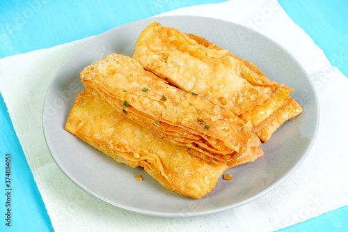 Crispy flour roti topped with sugar and chopped scallions