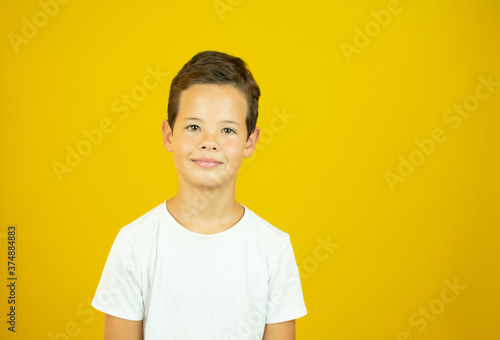 Portrait of a handsome boy smiling on yellow background