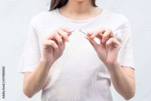 Stop smoking and Quit smoking cigarettes concept. Portrait of beautiful  girl holding broken cigarette in hands. Happy female quitting smoking cigarettes. Quit bad habit  health care concept.