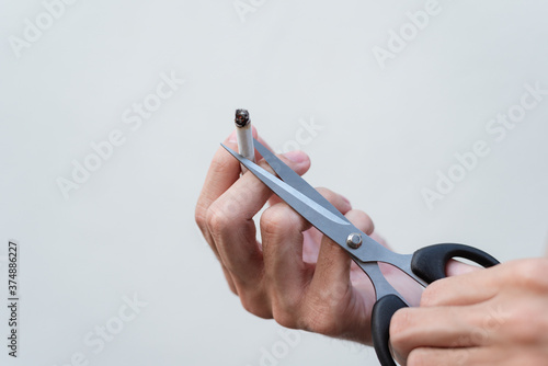 Man cuts a cigarette with scissors and Quit smoking.