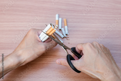 Man cuts a cigarette with scissors and Quit smoking.
