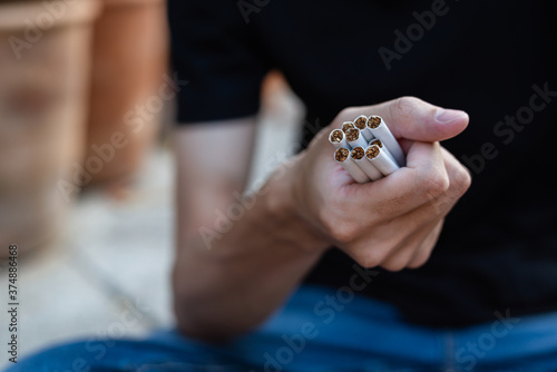Stop smoking and Quit smoking cigarettes concept. Handsome man holding  cigarette in hands. Quit bad habit, health care concept.