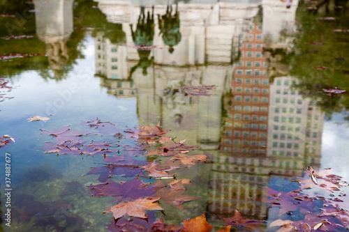 Beautiful Architecture and statue reflecting in the water with yellow leafs in Madrid  Spain in autumn time.