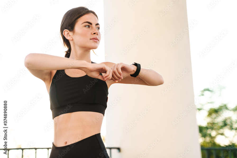 Image of young athletic sportswoman doing exercise while working out