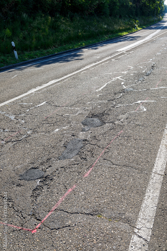 Fototapeta premium Landstraße mit Löcher und Risse