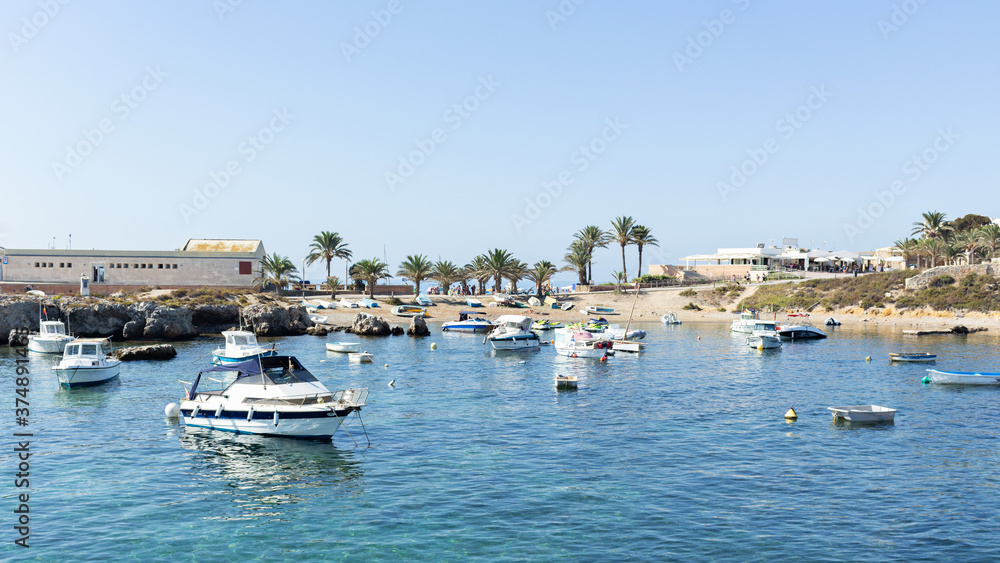 Landscape of the port of Tabarca with the sea with many boats with a clear blue sky in alicante, spain