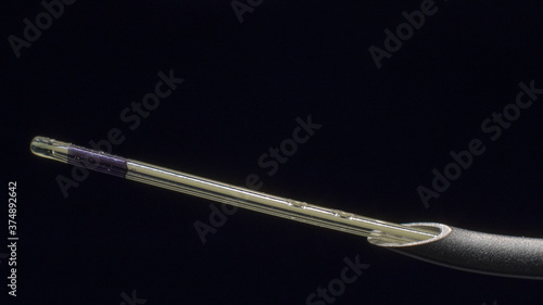 Macro-photography of epidural catheter appearing from 18G Tuohy epidural needle's tip.