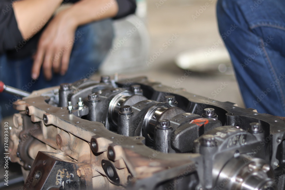 The mechanic is checking the engine. The mechanic is checking the engine.