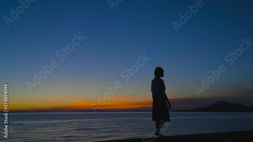 夏の夕暮れの海と女子高生