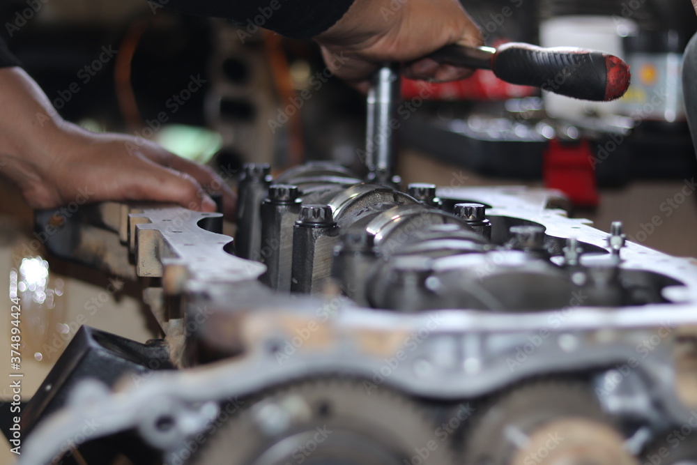 The mechanic is checking the engine.