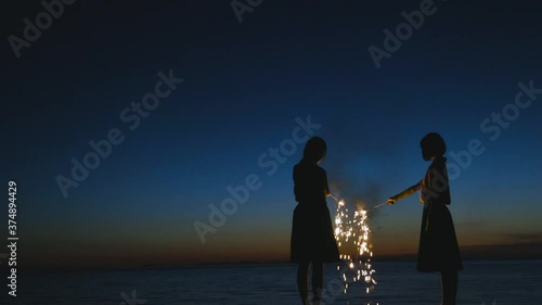 夕暮れに花火をする女子高生