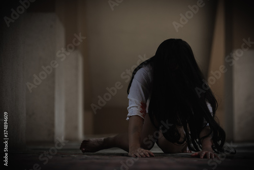 Girl zombie in blood. Asian Woman ghost with blood. Horror scary fear in dark house creepy crawling move slowly creeping out. Hair covering face her eye looking to camera  Halloween festival concept