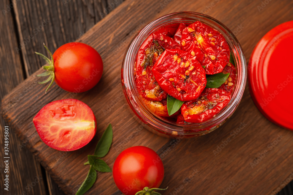 Top view of glass jar with sun-dried tomatoes seasoned with olive oil and spices Top view of glass jar with sun-dried tomatoes seasoned with olive oil and spices