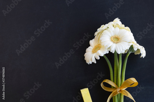 Teacher day concept. Bouquet of flowers, chalk on blackboard background. Top view, copy space