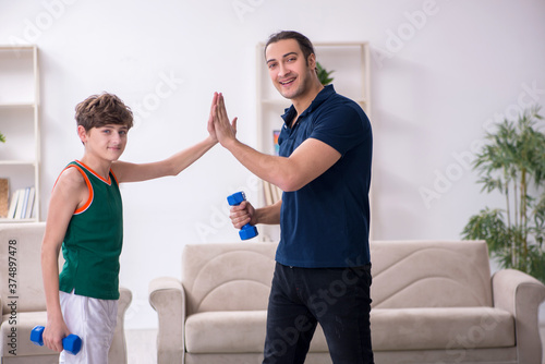 Father and son doing sport exercises indoors