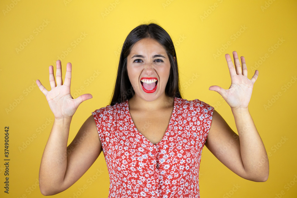 Young beautiful woman over isolated yellow background showing and pointing up with fingers number ten while smiling confident and happy Young beautiful woman over isolated yellow background showing and pointing up with fingers number ten while smiling confident and happy